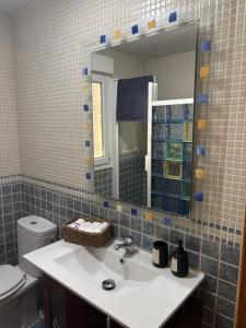 カンデレダにあるNeris Homeの洗面台、鏡、トイレ付きのバスルーム