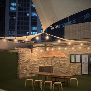 a wooden table and chairs with an umbrella and lights at No 25 Hotel Dongseongro branch in Daegu