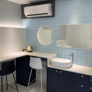 a bathroom with a sink and a counter with stools at No 25 Hotel Dongseongro branch in Daegu