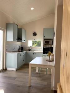 a kitchen with white cabinets and a table in it at Casa da Avó Lu in Assentiz