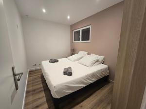 a bedroom with a bed with a pair of shoes on it at Sarah in Aix-les-Bains