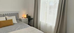 a bedroom with a bed next to a window at Central 1-bed flat - Walk to shops, pubs and station in Saltcoats