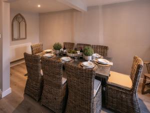 Un comedor con una mesa y sillas de mimbre. en Yew Tree Cottage, en Broadway