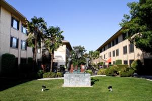 eine Statue im Gras vor einem Gebäude in der Unterkunft University Square Hotel in Fresno