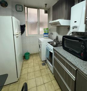 a kitchen with a white refrigerator and a sink at Departamento de 3 ambientes in La Porteña