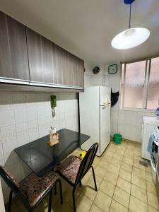 a kitchen with a table and two chairs and a refrigerator at Departamento de 3 ambientes in La Porteña +3 photos