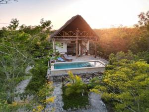 a small house with a swimming pool in a forest at Hotel Aldea Maya in Valladolid