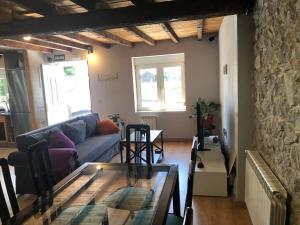 a living room with a couch and a glass table at Alojamiento Costa Quebrada in Soto de la Marina