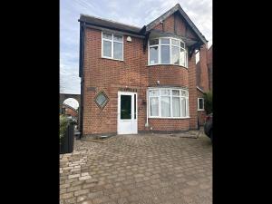 a brick house with a white door and a driveway at Gedling house in Nottingham