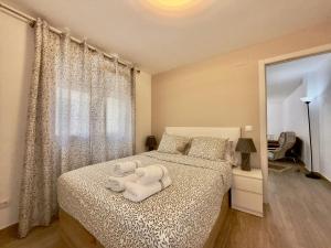 a bedroom with a bed with white sheets and a window at BAJ - Apartamentos en Playa Bajondillo, Torremolinos in Torremolinos