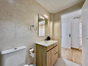 a bathroom with a sink and a toilet and a mirror at BAJ - Apartamentos en Playa Bajondillo, Torremolinos in Torremolinos