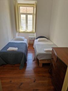 two beds in a small room with a window at Casa 7 in Setúbal +11 photos