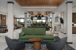 a lobby with a green couch and chairs at Fairfield by Marriott Inn & Suites Sikeston in Sikeston