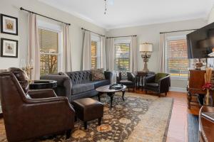 Una sala de estar con un sofá y sillas y ventanas. en Bourbon Getaway!!! Hot Tub, Fire Pit, Distilleries, en Springfield