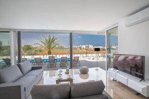 ein Wohnzimmer mit Sofa und Fernseher in der Unterkunft Villa Manta Platina - Brand New Luxury 3 Bedroom Protaras Villa in Protaras