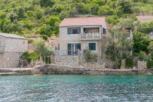 a house on the shore of a body of water at Apartments by the sea Cove Donja Kruscica - Donja Krusica, Solta - 11146 in Grohote +14 photos