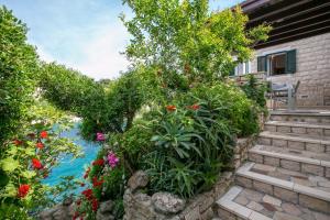 a garden with flowers and stairs next to a house at Apartments by the sea Cove Donja Kruscica - Donja Krusica, Solta - 11146 in Grohote