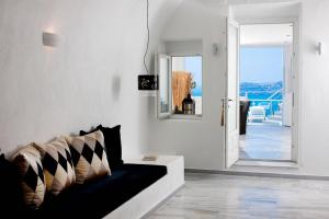 un salon avec un canapé et une vue sur l'océan dans l'établissement Venetian-Style Santorini Villa 1 Bedroom Villa Astroglia Beautiful Caldera Sea Views & Private Jacuzzi Fira, à Fira