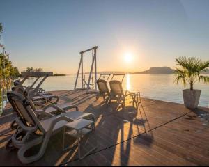 un gruppo di sedie seduti su un molo vicino all'acqua di Chill&Lake Sunset 205-304 a Fonyód