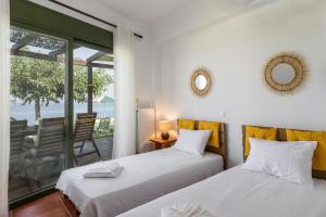 two beds in a room with a view of the ocean at Orianthi's Beachfront Home in Skala