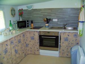 una cocina con fregadero y estufa horno superior en Gîte authentique avec terrasse, jardin clos et wifi à La Garnache - FR-1-426-140, en La Garnache 15 fotos más