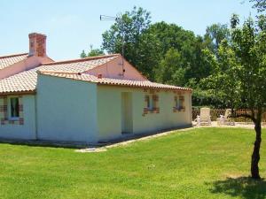 una pequeña casa blanca con un patio de césped en Gîte authentique avec terrasse, jardin clos et wifi à La Garnache - FR-1-426-140, en La Garnache
