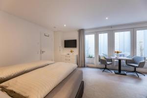 a bedroom with two beds and a desk and a table at Haus-Andersen-Ferienwohnung-2 in Norderney