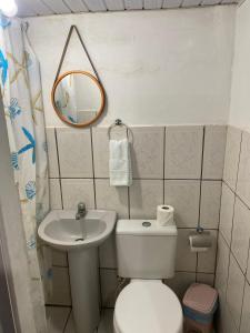 a bathroom with a toilet and a sink and a mirror at Casa da Silvana in Fernando de Noronha