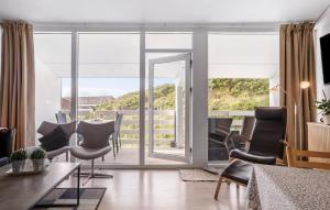 a living room with a table and chairs and sliding glass doors at Beautiful Apartment In Ringkøbing in Ringkøbing