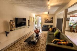 a living room with a couch and a tv at Casa Villa Fontana - Condomínio à beira-mar e próximo ao aeroporto - Praia de Itapuã in Salvador