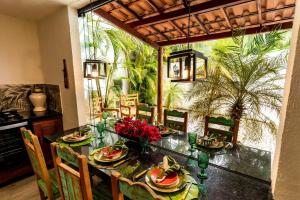 a dining room with a table and chairs and plants at Casa Villa Fontana - Condomínio à beira-mar e próximo ao aeroporto - Praia de Itapuã in Salvador