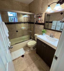 a bathroom with a toilet and a sink and a shower at Cozy Retreat, Families, Digital Nomads & Retirees in Pompano Beach