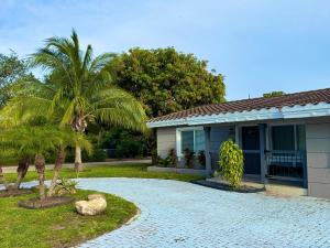 a house with a palm tree in front of it at Cozy Retreat, Families, Digital Nomads & Retirees in Pompano Beach
