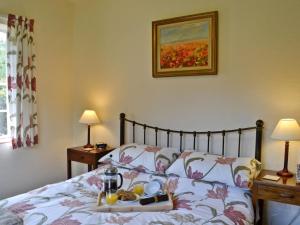 a bedroom with a bed with a tray of food on it at The Old Post Office in Eaton Bishop