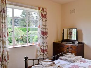a bedroom with a bed and a window at The Old Post Office in Eaton Bishop