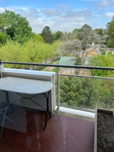 ein Balkon mit Tisch und Blick auf Bäume in der Unterkunft Arsène 3 l'Hermitage in Le Touquet-Paris-Plage