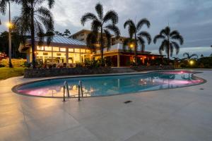 two people standing in front of a swimming pool at Refugio Caribeño in Puerto Limón