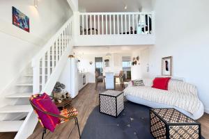 a living room with a couch and a staircase at L’adresse rêvée Balcon vue mer in Ploemeur +41 photos
