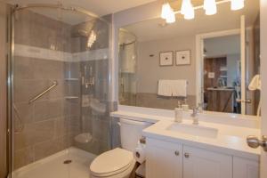 a bathroom with a shower and a toilet and a sink at 2BR Deer Lodge, Epic Location, Private Covered Patio, Free Parking in Whistler