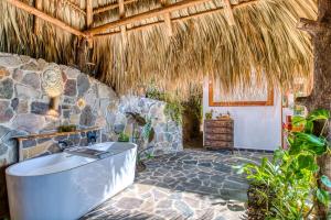 a bathroom with a tub and a stone wall at The Bird Nest at Casa Paloma in San Marcos La Laguna