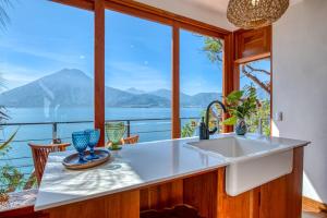 a kitchen with a sink and a large window at The Bird Nest at Casa Paloma in San Marcos La Laguna +3 photos