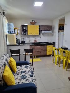 un soggiorno con divano e sedie in cucina di Lençóis Park Residence Flat 106 Caburé a Barreirinhas