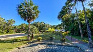 un parco con palme e un sentiero con piante di Lençóis Park Residence Flat 106 Caburé a Barreirinhas