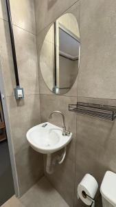 a bathroom with a sink and a mirror at Suíte 15 • Praia das Pitangueiras in Guarujá +26 photos