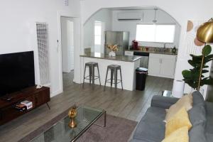 a living room with a couch and a table and a kitchen at Casa Mid City - Centrally Located 1BR Getaway with Private Yard in Los Angeles
