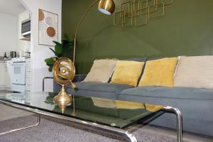 a living room with a blue couch and a glass table at Casa Mid City - Centrally Located 1BR Getaway with Private Yard in Los Angeles