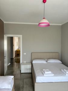 a bedroom with two beds and a pink lamp at Emma's Apartments in Tirana
