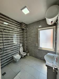 a bathroom with a sink and a toilet and a window at Emma's Apartments in Tirana +22 photos