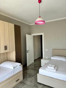 a bedroom with two beds and a pink light at Emma's Apartments in Tirana