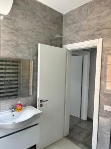 a bathroom with a sink and a mirror at Emma's Apartments in Tirana